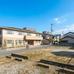 大阪の住宅地にある更地または建て替え候補地を前景に、背景に高齢者施設や街並みを置いた写真