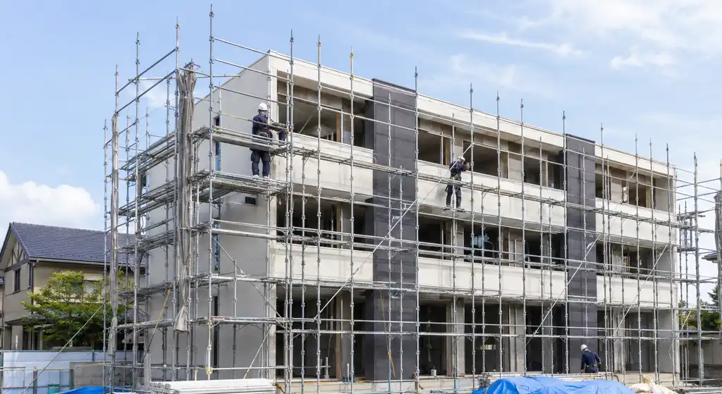 足場が組まれた賃貸マンションの新築工事現場